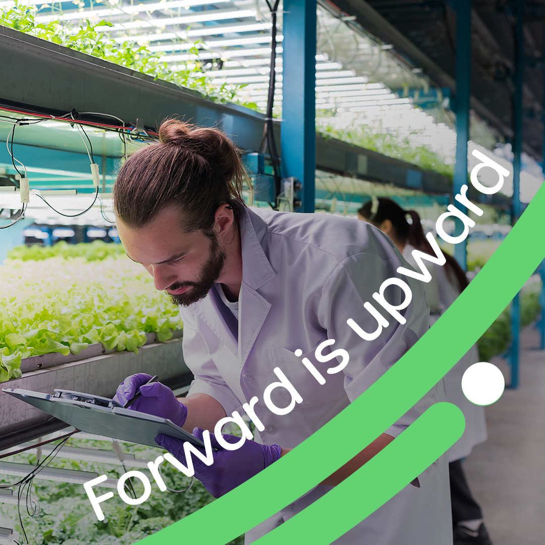 Man in a brightly lid greenhouse, with the chasing lines of Enza Zaden and the text Forward is upward