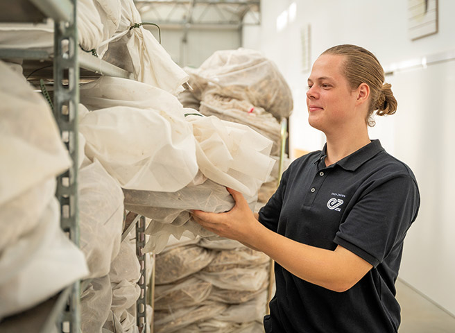 Jovem mulher a recolher um saco de sementes do armazém